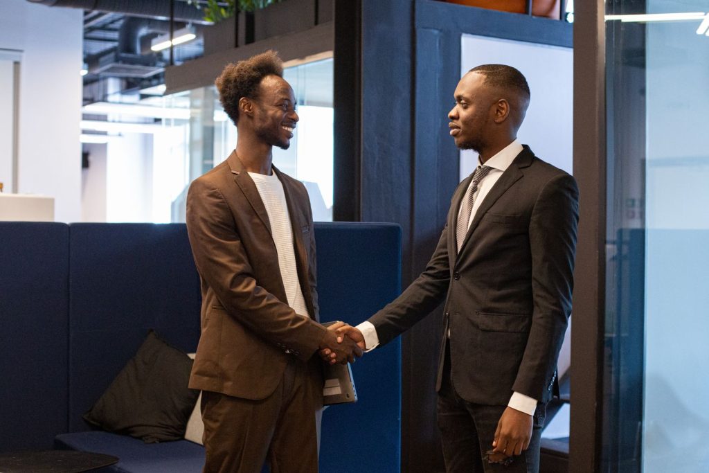 Two professionals shaking hands at the start of a project meeting
